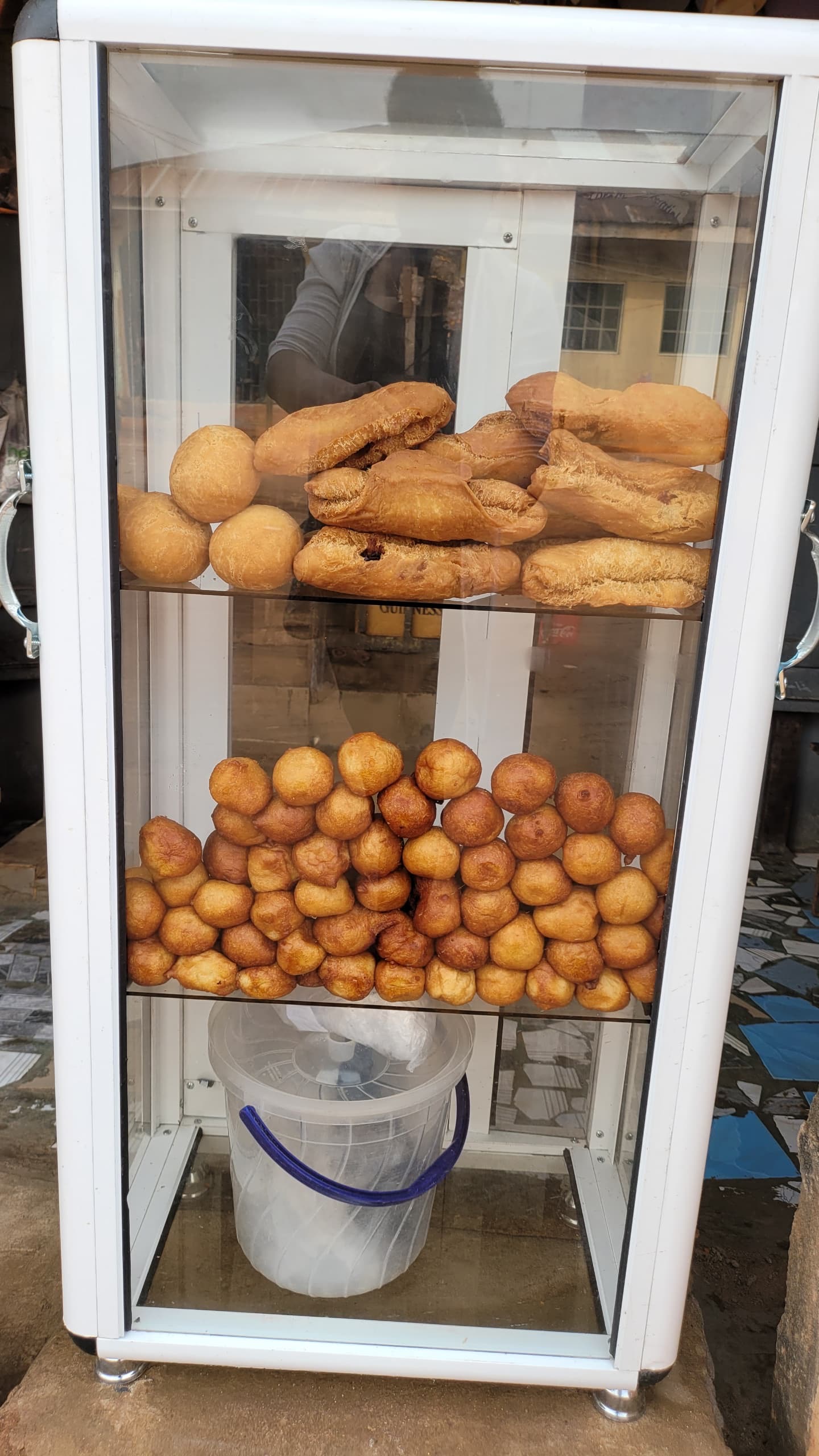 A Glass Casing showcasing fried snack like puff puff, fish roll, egg roll. 