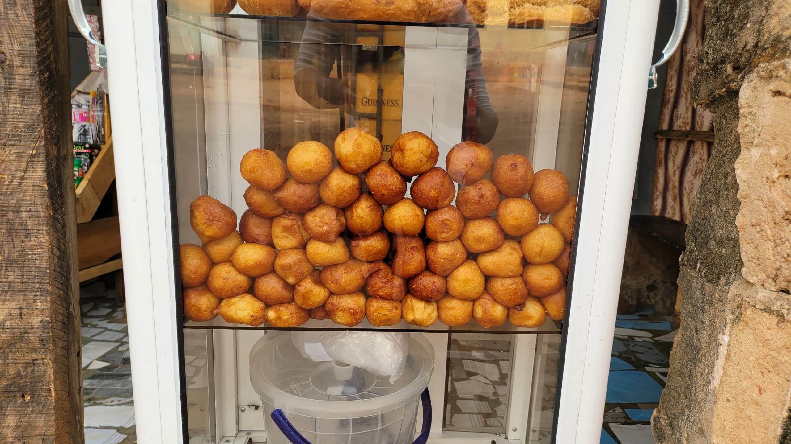 Puff puff neatly arranged in a glass casing.