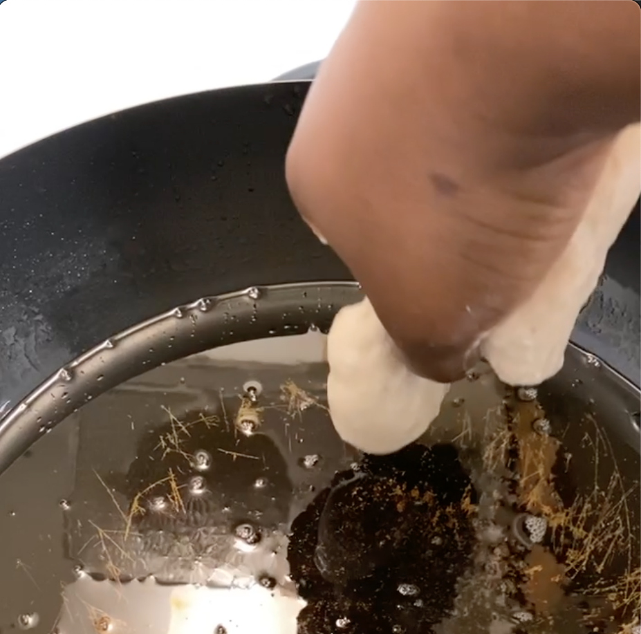 Then turn the hole between your index finger and your thumb towards the hot oil so it freely falls into it.